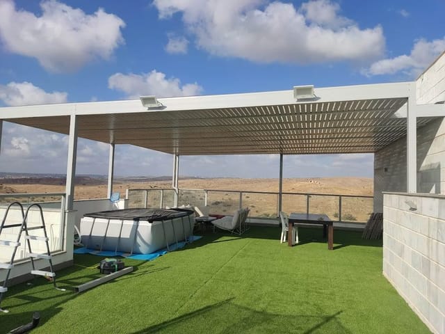 פרגולה לבנה גדולה עם שלבים צפופים על גג עם דשא סינתטי ונוף פתוח
