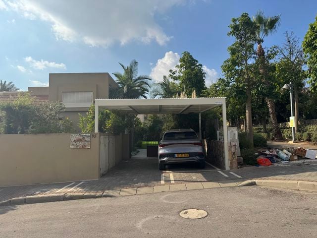 פרגולת אלומיניום לבנה מעל חניה בכניסה לבית פרטי, מבט מהרחוב – דגם כניסה VIP