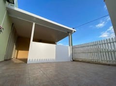 פרגולה מקורה לבנה ליד גדר עץ לבנה, מבט רחב מהריצוף