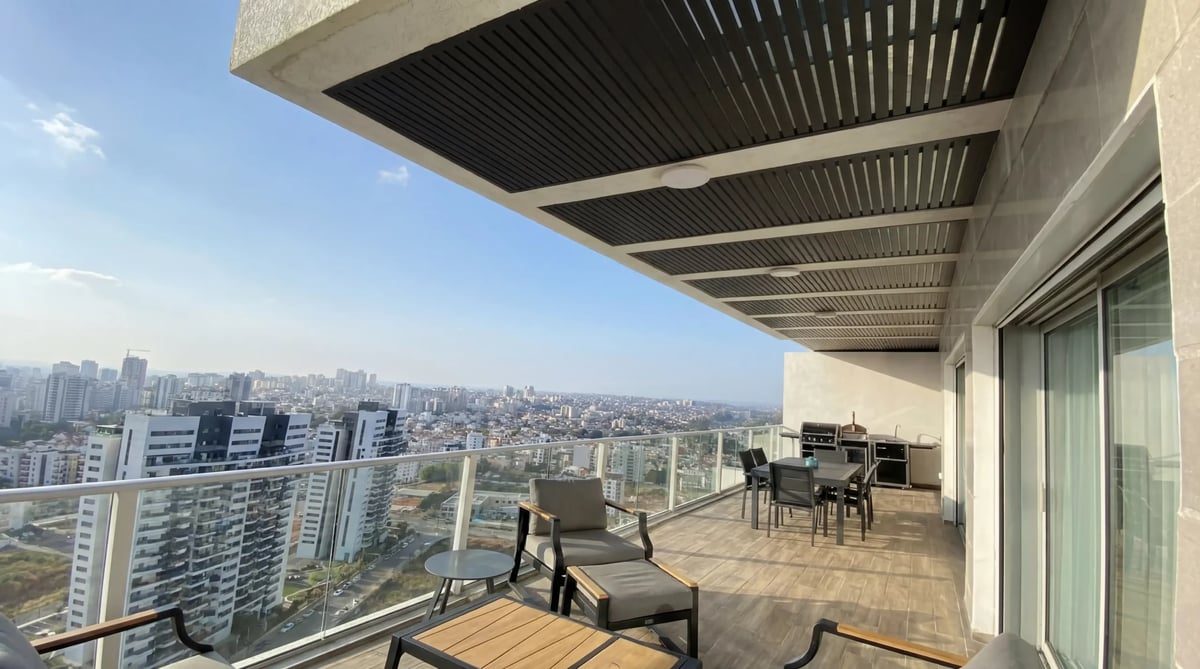מרפסת מגדל רחבה עם פרגולה תלויה כהה, פינת אוכל ומטבח חוץ