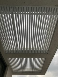 מבט ישר מלמטה על שלבים לבנים בשני פתחי קירוי במסגרת בטון